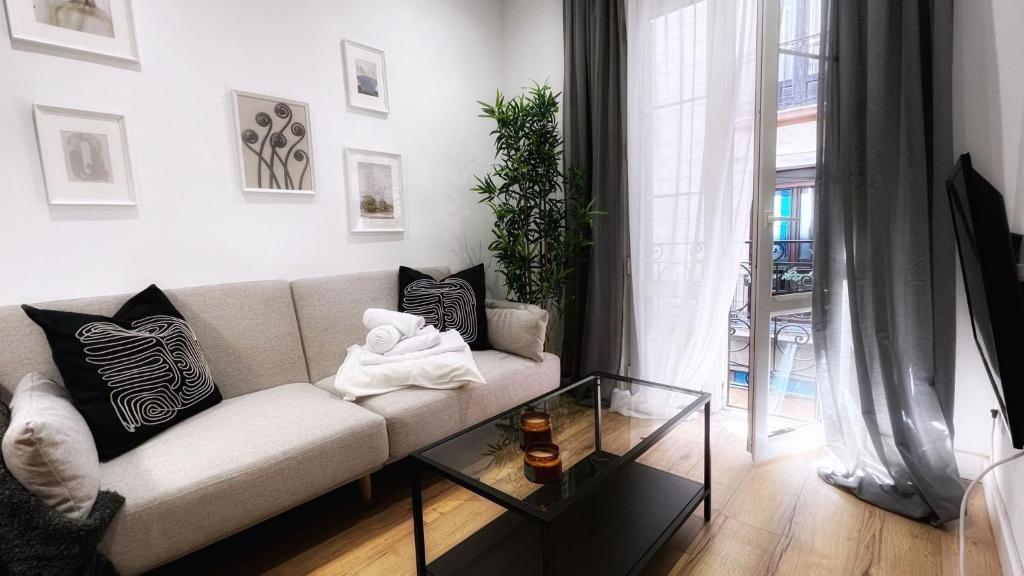 a living room with a couch and a glass table at Bilbao Ronda apartamento con balcón Casco Viejo in Bilbao