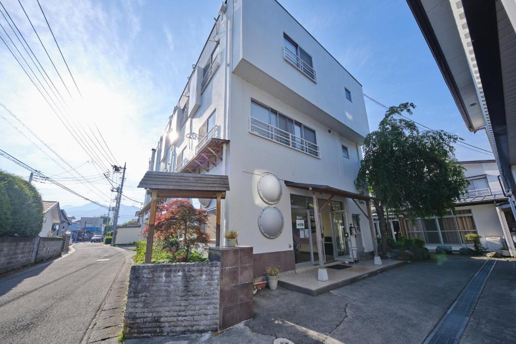 a white building on the side of a street at Fuyo Sankyo Enka in Fujikawaguchiko