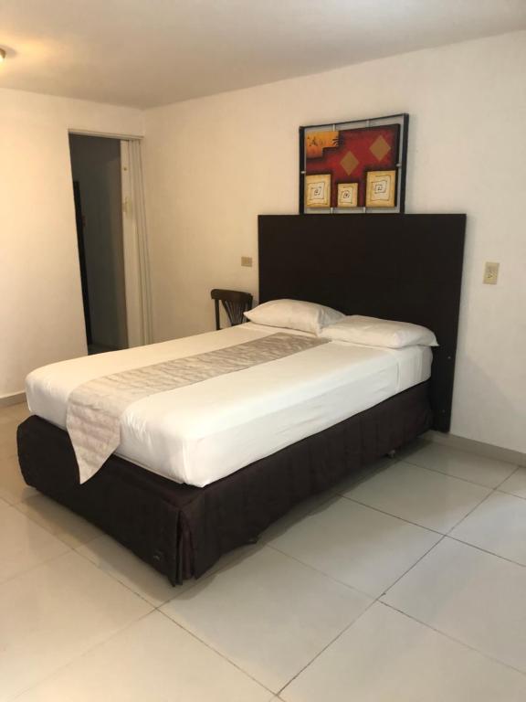a bedroom with a large bed with a black headboard at Casa Playa Hermosa in Cancún