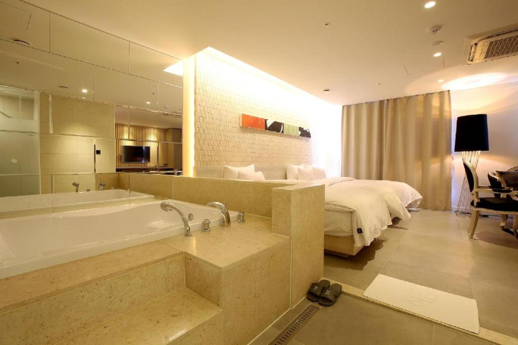 ソウルにあるHotel Lassaのバスルーム(バスタブ付)、ベッド1台、ベッドルーム1室が備わります。