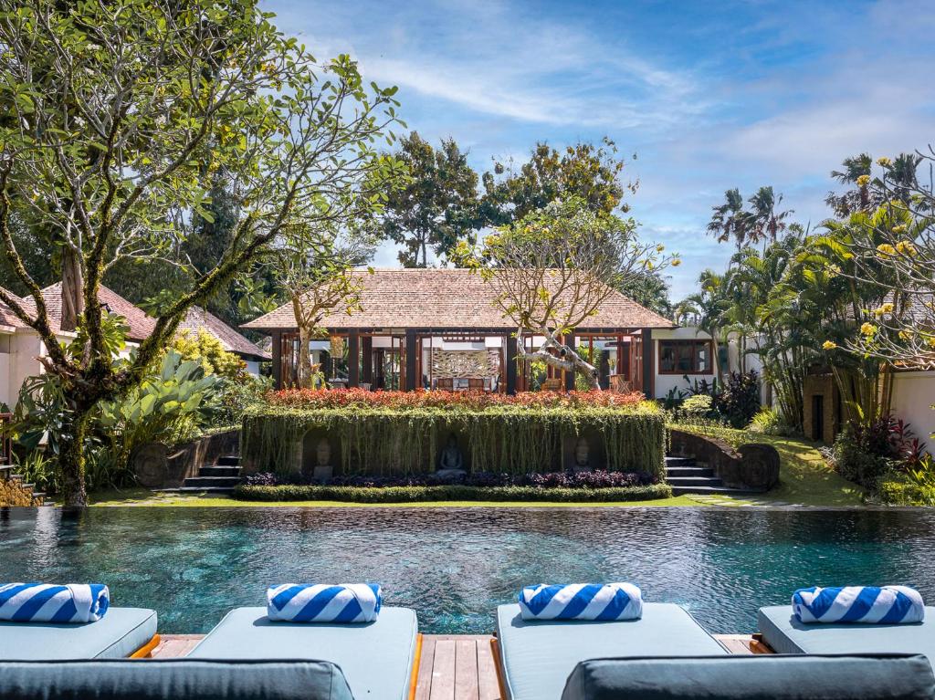 une maison avec une piscine et des chaises longues dans l'établissement Villa Simona Oasis, à Canggu