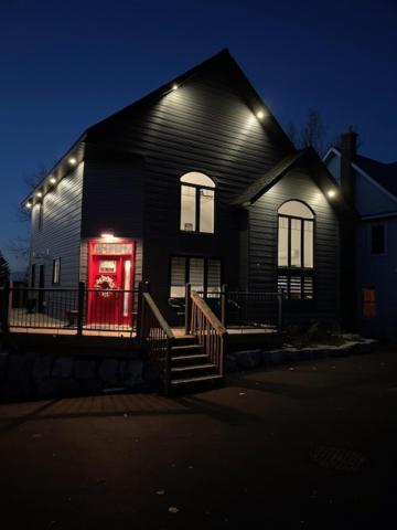 a black house with a red door at night at Sunsets At The Oasis in Napanee