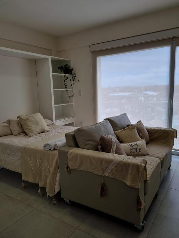 a bedroom with a bed and a large window at Bella Vista in Cipolletti