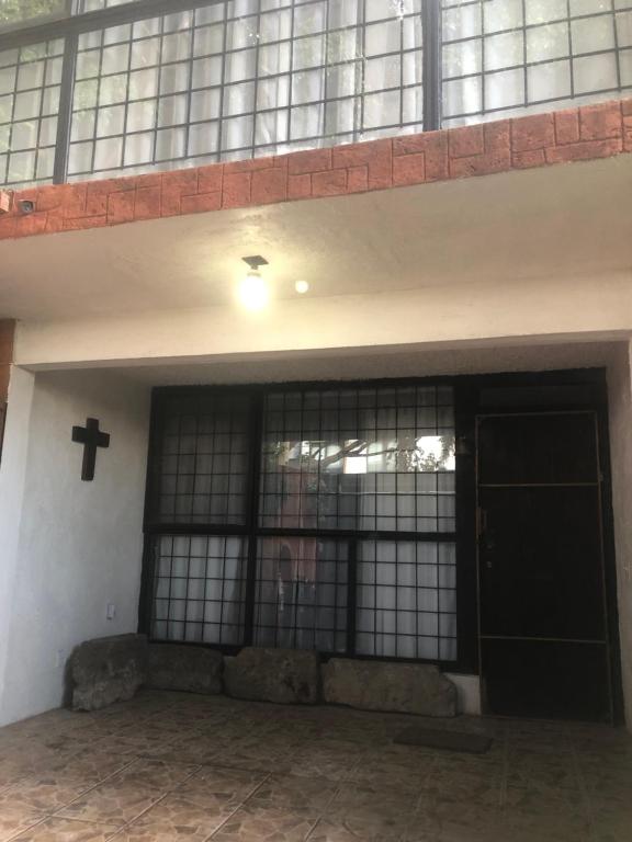 un edificio con una puerta negra y una cruz en la pared en Maru's House en Guadalajara