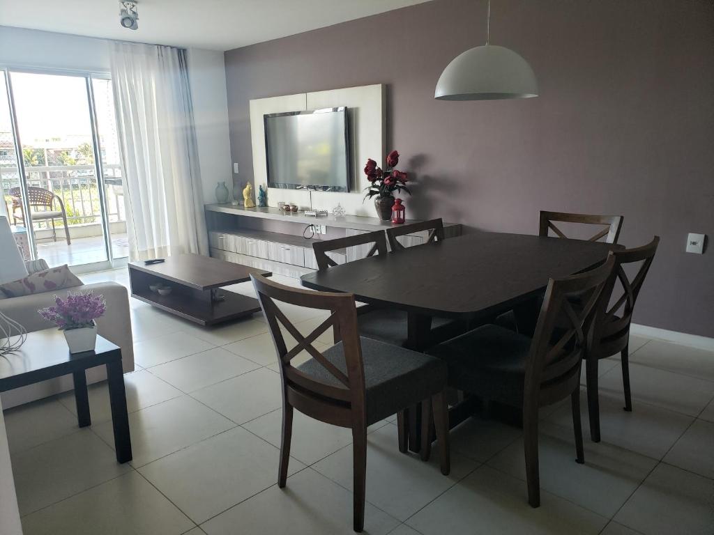 ein Wohnzimmer mit Tisch und Stühlen und einem Fernseher in der Unterkunft Apto Completo l Excelente Vista em Golf Ville Resort in Aquiraz