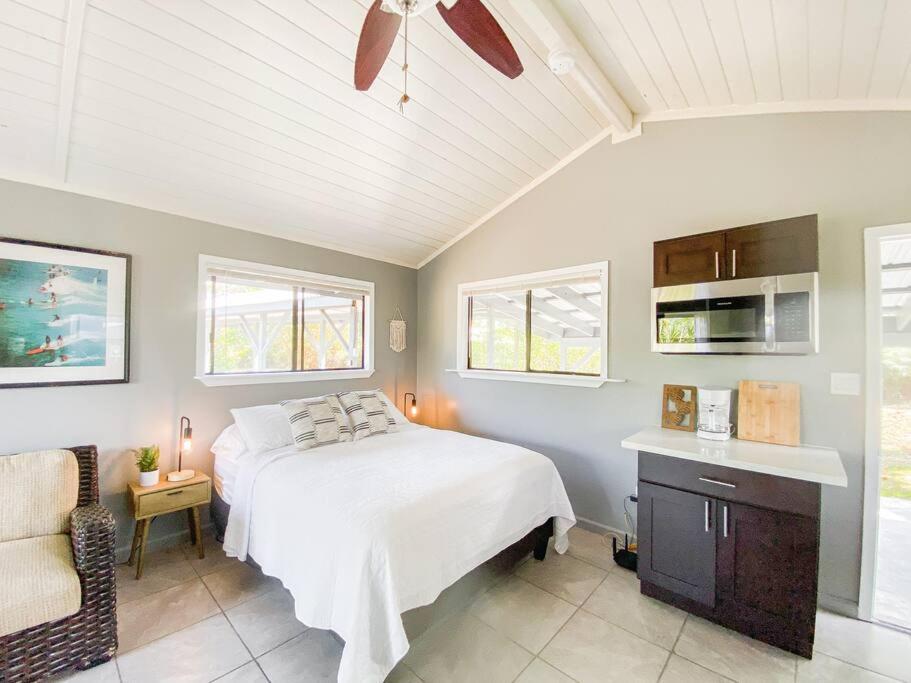 a bedroom with a bed and a ceiling fan at Surf Getaway, Queen Bed, Private Lanai in Keaau