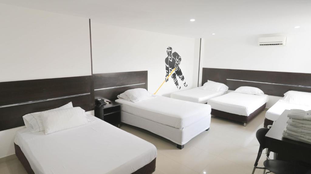 a room with four beds with white sheets at AW Hotel Sport in Cali