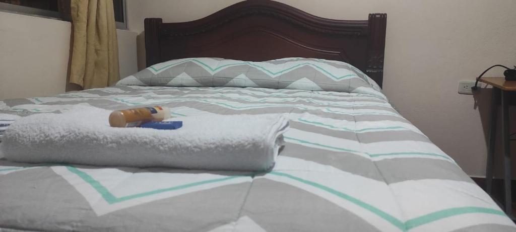un letto con un animale di peluche sopra gli asciugamani di Alójate con Estefany a Latacunga