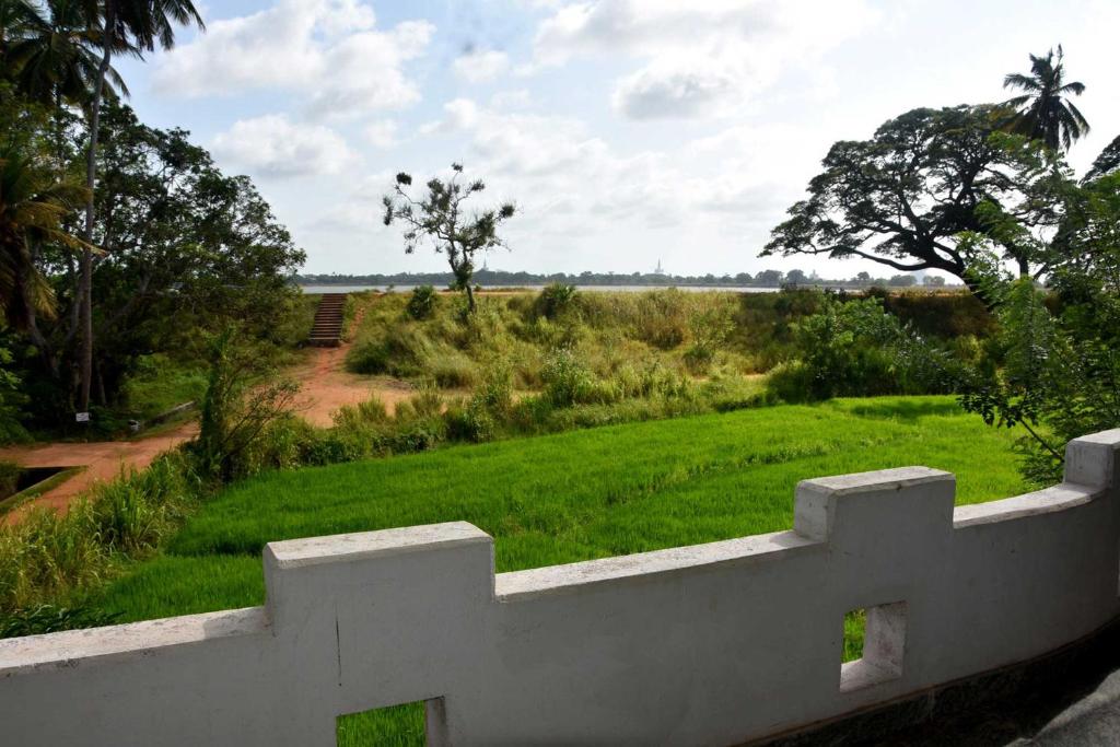 einen weißen Zaun vor einem Grasfeld in der Unterkunft Royal Views Residence in Anuradhapura