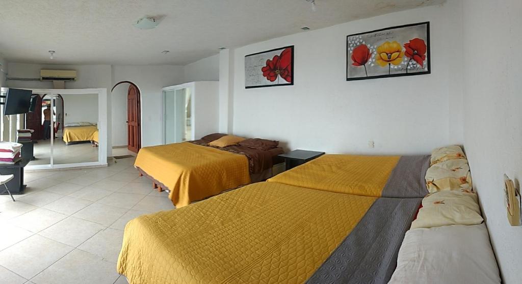 Habitación de hotel con 2 camas y espejo en Campanario07 en Acapulco