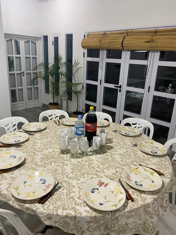 een tafel met borden en een fles frisdrank erop bij Caralí home in Esquina