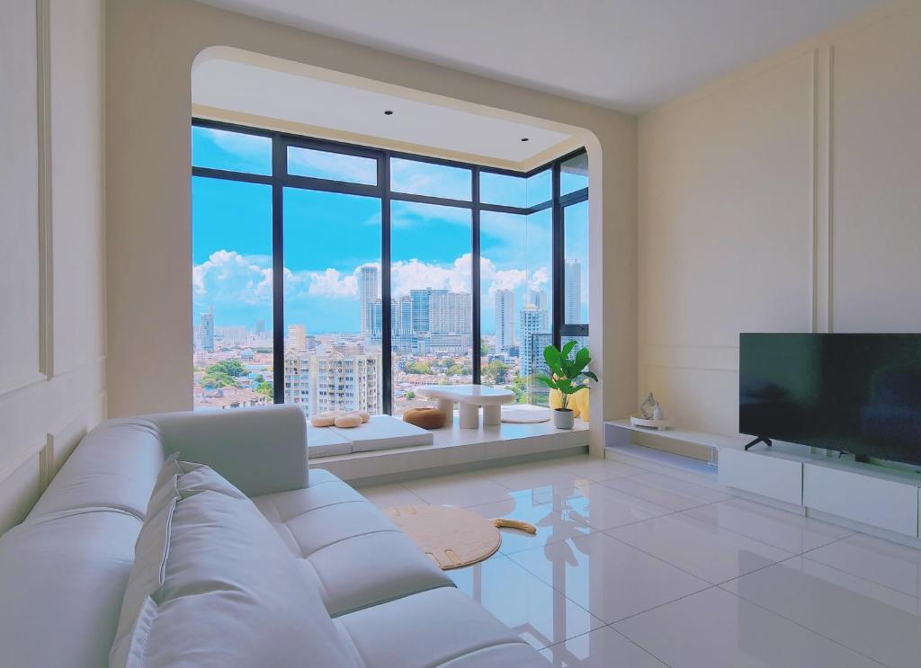 a living room with a white couch and a large window at SkyPool with Seaview 8pax Beacon Executive Suites - Georgetown City Centre - 3km to Komtar in George Town
