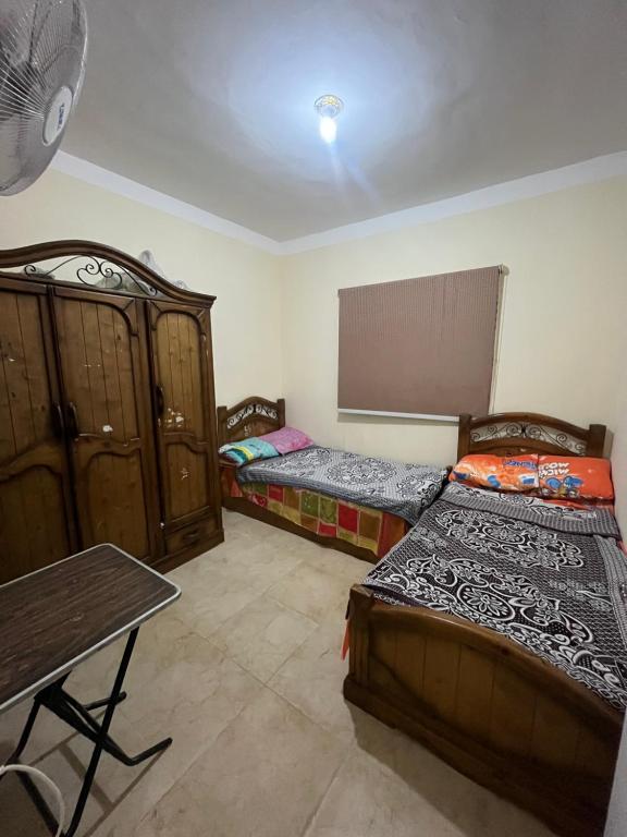 a room with two beds and a table in it at Two bedrooms Challet at Retal View North coast in El Alamein