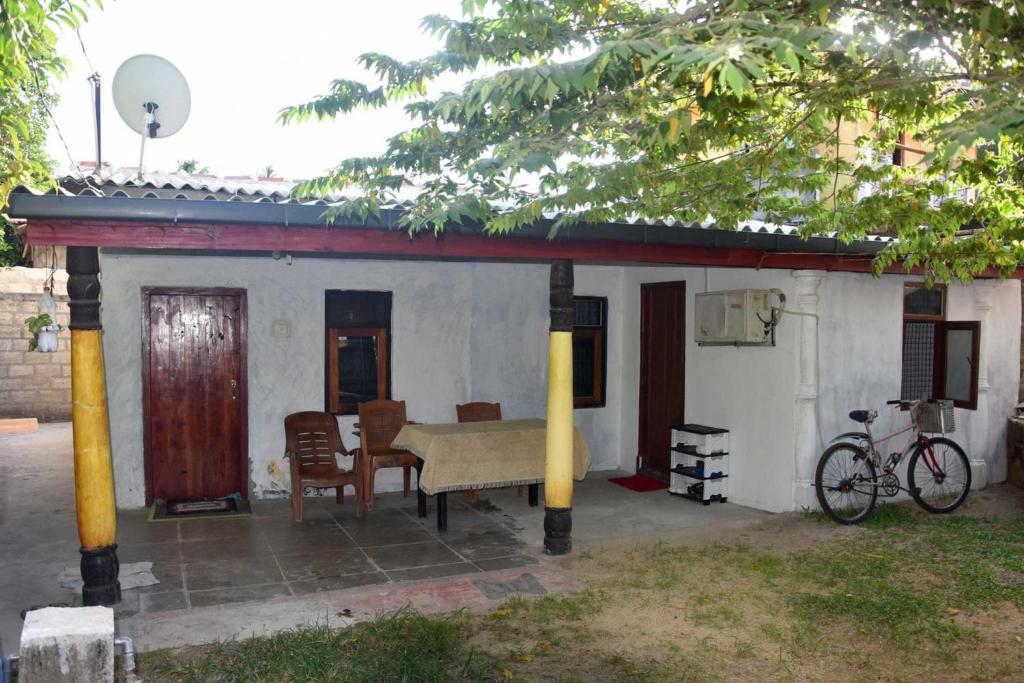 ein Haus mit einem Tisch und Stühlen davor in der Unterkunft Meera Homestay in Anuradhapura