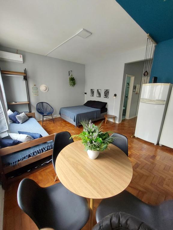 uma sala de estar com uma mesa e um sofá em Studio pertinho do mar! Pitangueiras/Guarujá no Guarujá