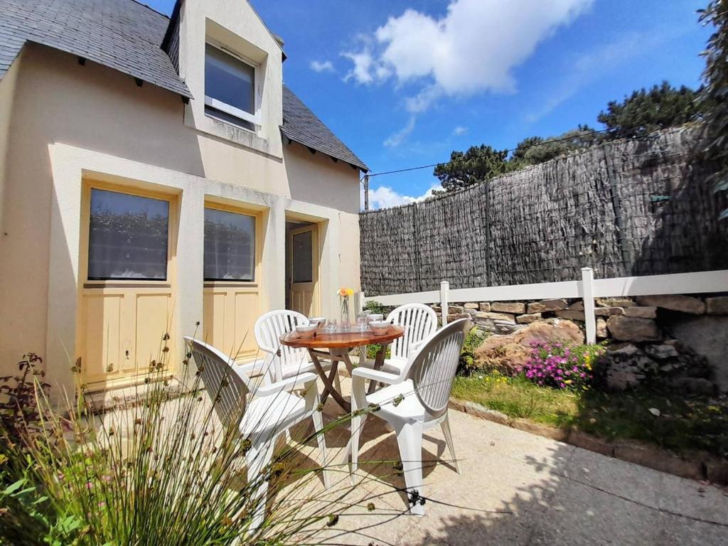 un patio avec une table et des chaises devant une maison dans l'établissement Maison cosy 3 pièces avec terrasse à 800m de la plage - Wifi, lave-vaisselle, parking public - FR-1-477-238, à La Trinité-sur-Mer