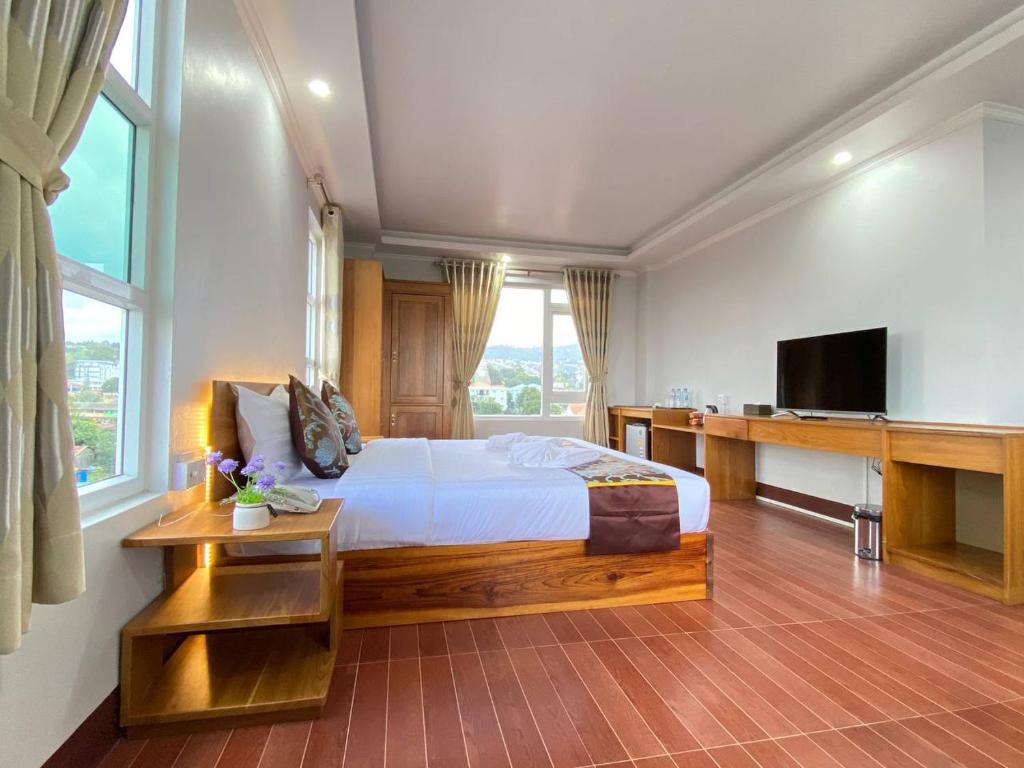 a bedroom with a large bed and a television at LOI LOUNG HOTEL in Taunggyi