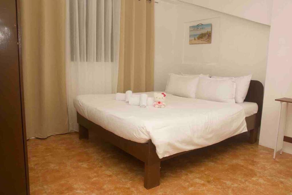 um quarto com uma cama com lençóis brancos e almofadas brancas em Casa de Primera B31 beach front station 3 em Boracay