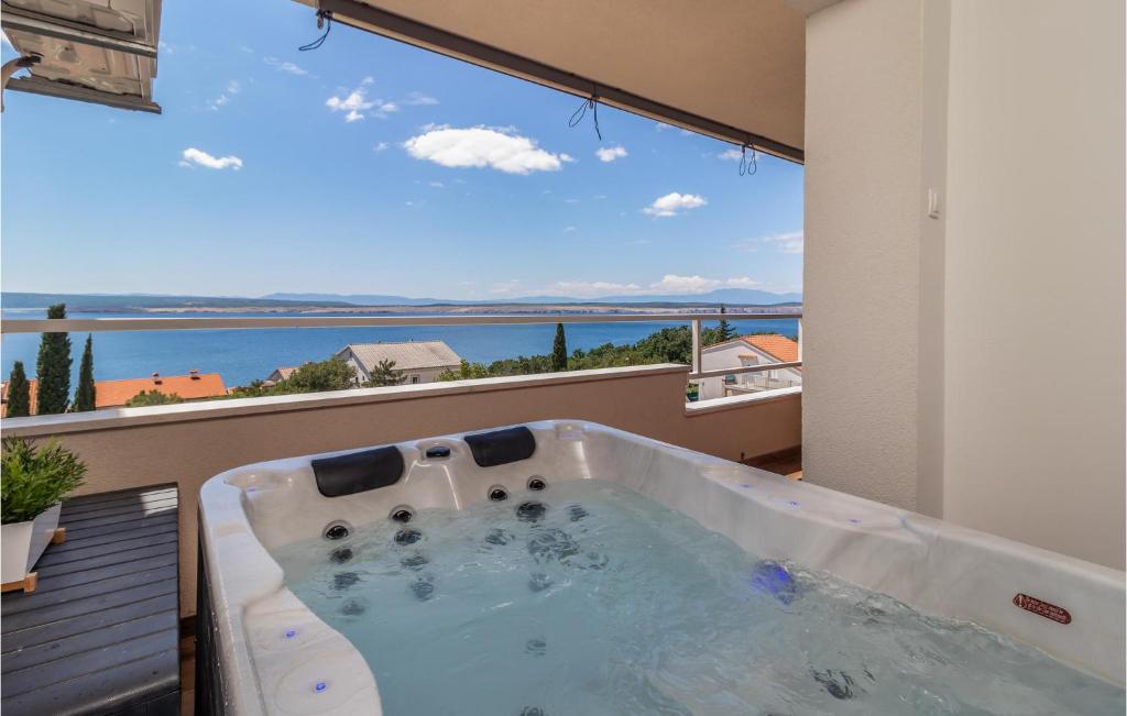 a bath tub on a balcony with a view of the ocean at Nice Apartment In Dramalj With House Sea View in Dramalj