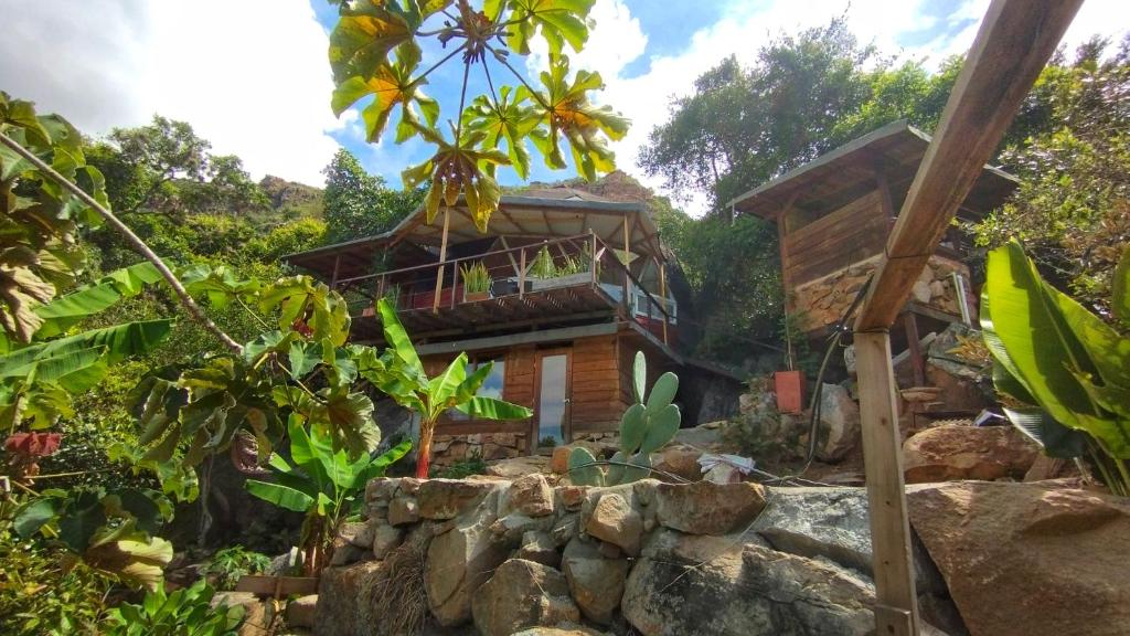 una casa en un bosque con una pared de piedra en Domo Geodésico frente al Cañón del Chicamocha, en Los Santos