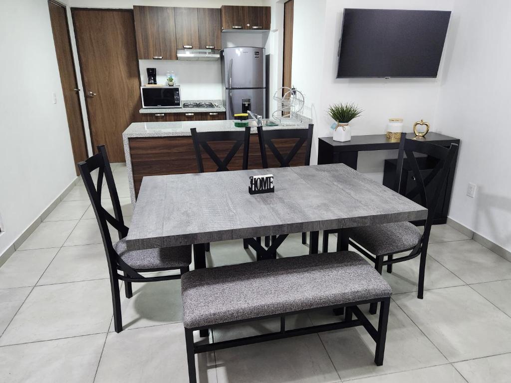 einen Esstisch und Stühle mit einer Küche im Hintergrund in der Unterkunft Nuevo y amplio departamento con alberca y seguridad en el centro de Guadalajara in Guadalajara