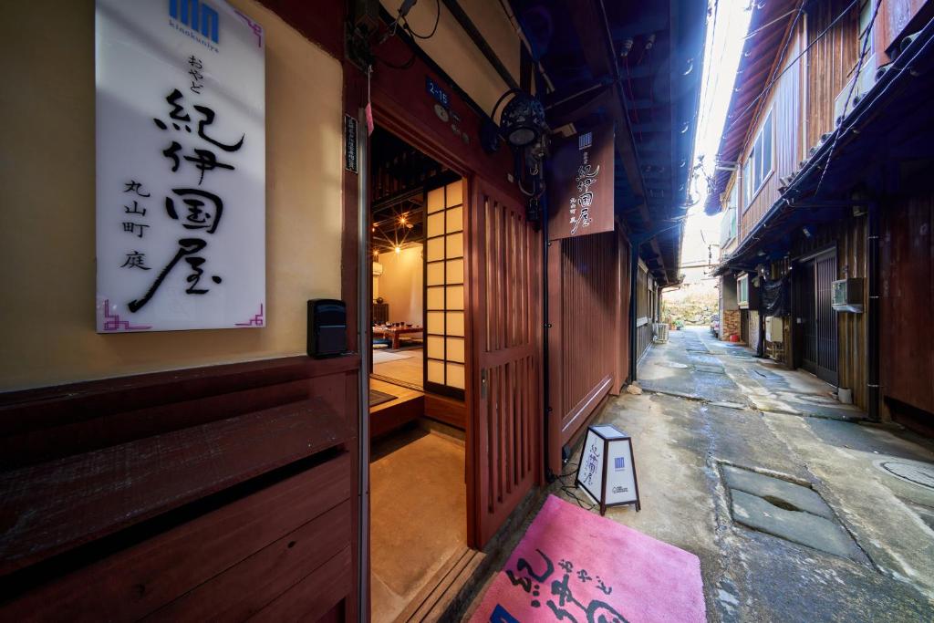 un vicolo con un cartello sul lato di un edificio di おやど紀伊国屋 丸山町 庭 a Nagasaki