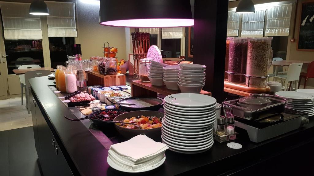 a buffet line with plates and bowls of food at Campanile Saint-Etienne Est- Saint-Chamond in Saint-Chamond