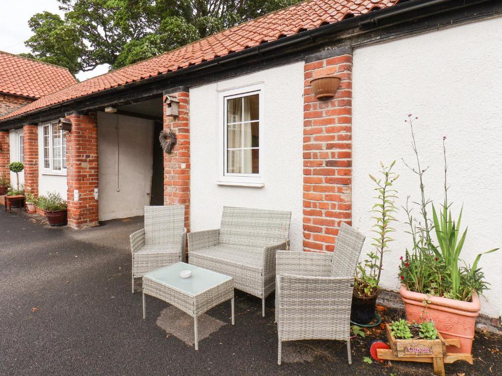 a group of chairs and a table in front of a house at Cupid's Cottage in Bessingby