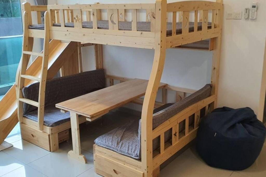 a bunk bed with a bench and a table at Kid Slide Family Apartment with 2 Bedroom + 2 Bath in Masai