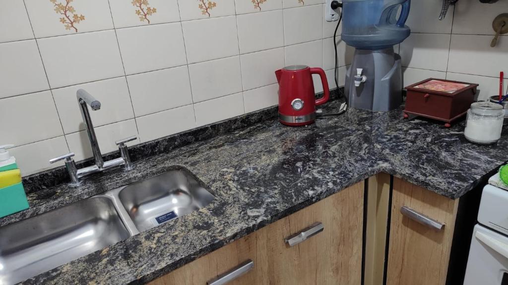 encimera de cocina con fregadero y licuadora roja en Botanical house en San Miguel de Tucumán