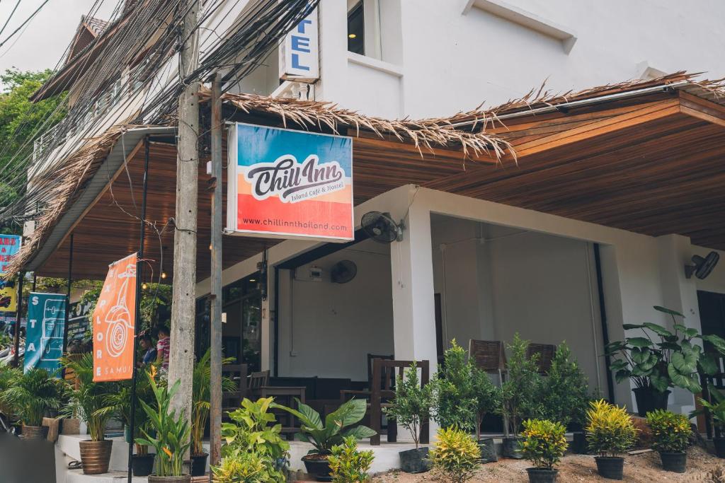 un restaurant avec un panneau sur le côté d'un bâtiment dans l'établissement Chill Inn Chaweng Island Cafe and Hostel, à Ban Nai Na