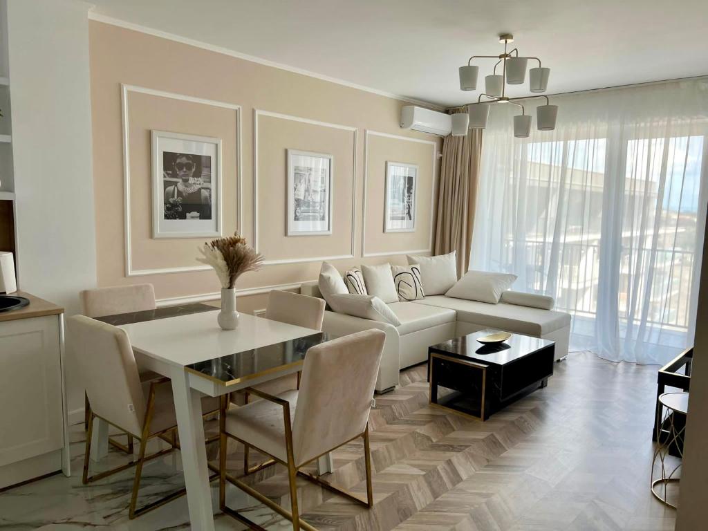 a living room with a table and a couch at GLIM SUITE in Oradea