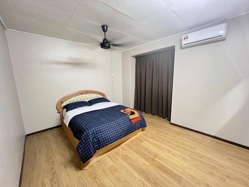 ein Schlafzimmer mit einem Bett in einem Zimmer in der Unterkunft Netflix Wifi (3 Rooms) Homestay Kak Nad Saujana Utama in Sungai Buloh