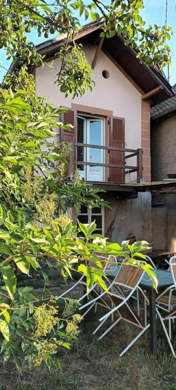 ein Haus mit einem Balkon und Stühlen davor in der Unterkunft Au jardin de la Maison des Soeurs in Mutzig