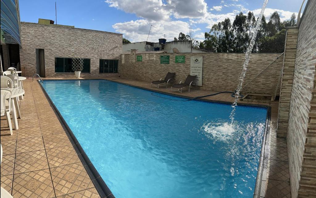 a large swimming pool with a water fountain at Hotel Anápolis in Anápolis