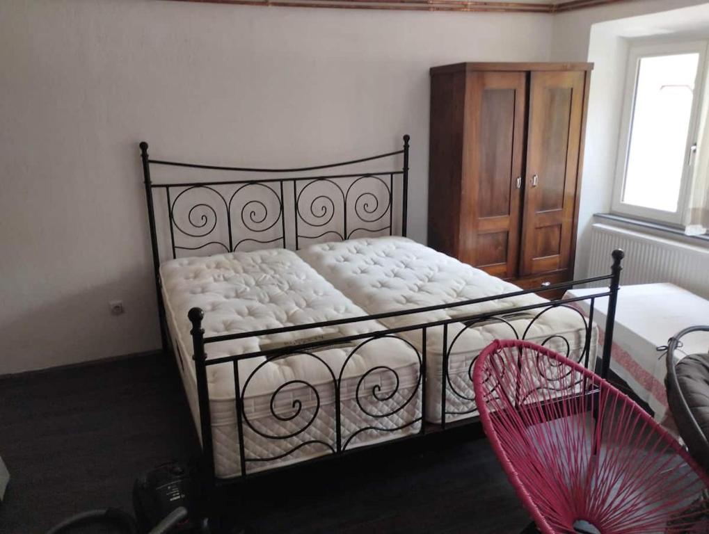 1 dormitorio con 1 cama con armario de madera y ventilador rojo en Lux apartments and rooms Dogs baronesse Idrija en Idrija