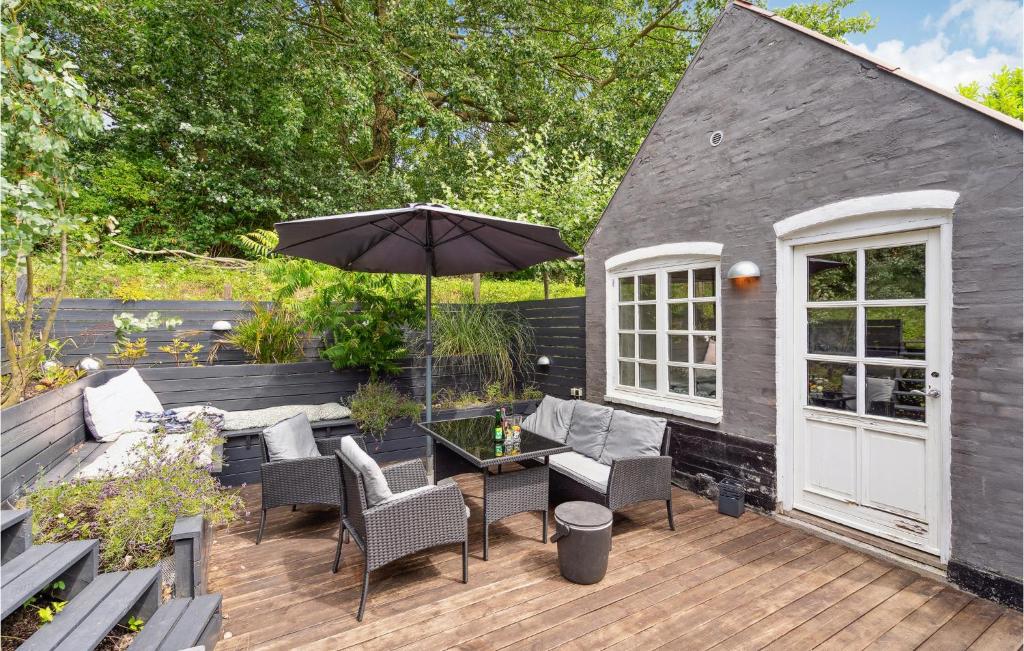 a patio with a table and chairs and an umbrella at 2 Bedroom Pet Friendly Home In rskbing in Ærøskøbing
