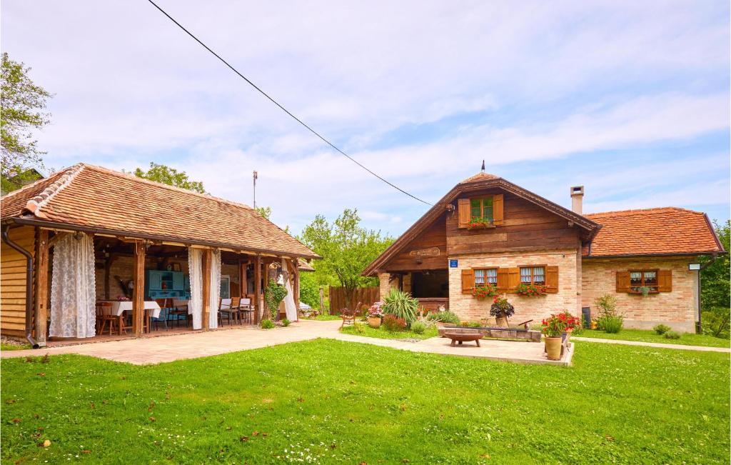 Cette maison dispose d'une terrasse et d'une cour avec gazon. dans l'établissement 2 Bedroom Cozy Home In Hrastovica, 