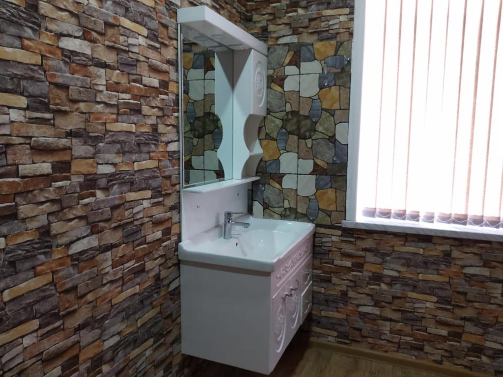 een badkamer met een wastafel en een bakstenen muur bij Red Villa Big swimming pool in Gabala