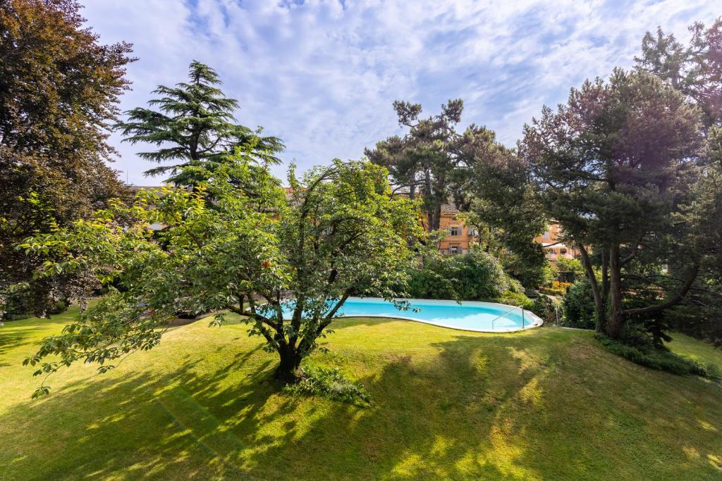 einen Blick über einen Pool in einem Park mit Bäumen in der Unterkunft Hotel Elephant in Brixen