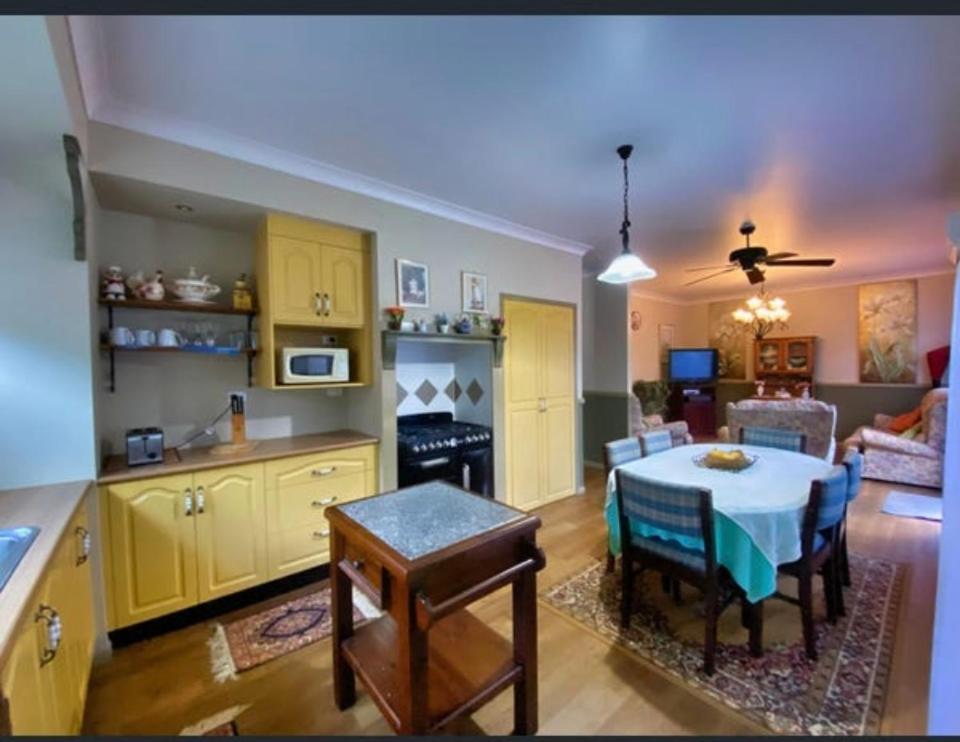 a kitchen and living room with a table and a living room at GOLDEN LACE B&B in Sarina