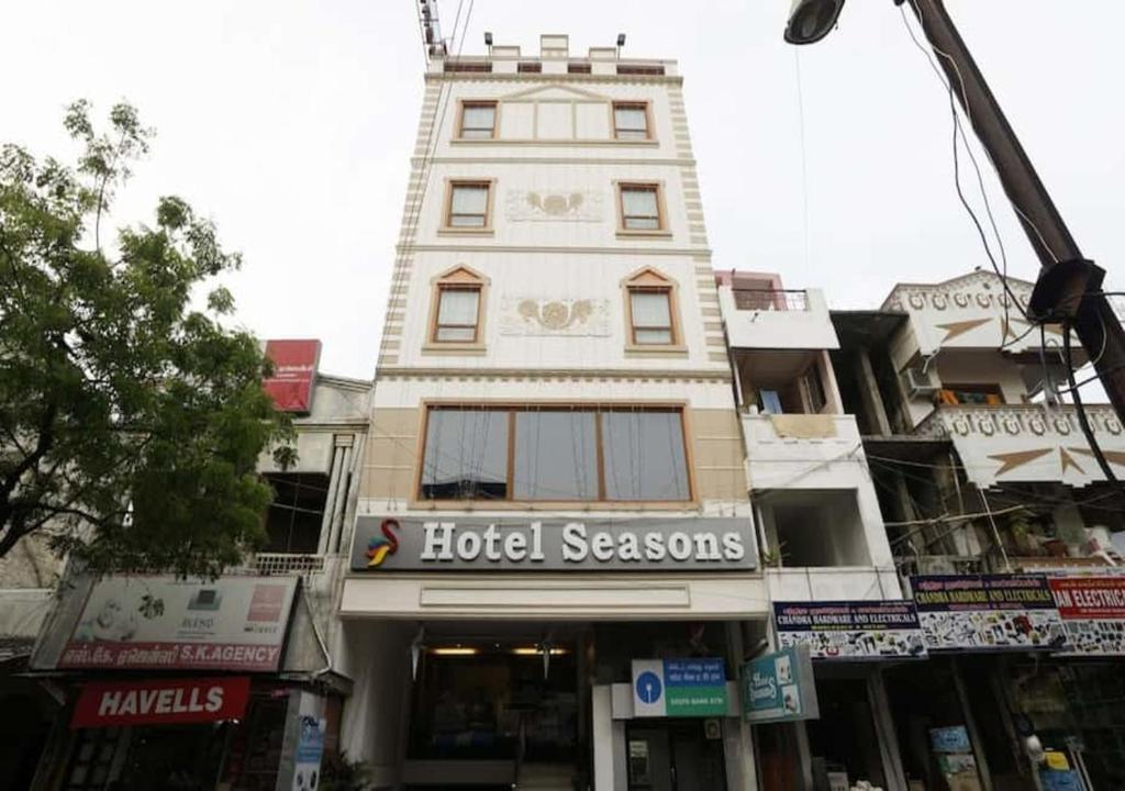 un edificio alto con un cartel de estaciones de hotel en Hotel seasons, en Pondicherry
