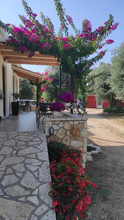 a garden with pink flowers and a stone wall at Sivota Casa Cleopatra in Sivota