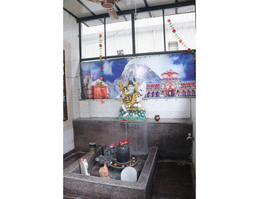 un murale sulla parete di una stanza con un santuario di Hotel Gopi Dham, Haridwar a Haridwār