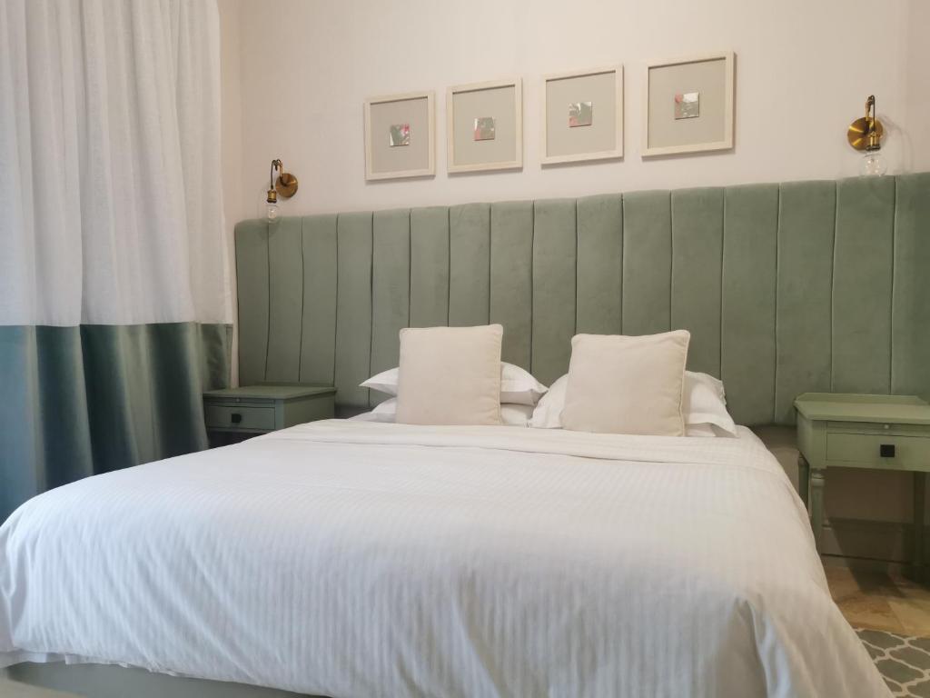 a bedroom with a large bed with white sheets and pillows at Little Scotia in Cape Town