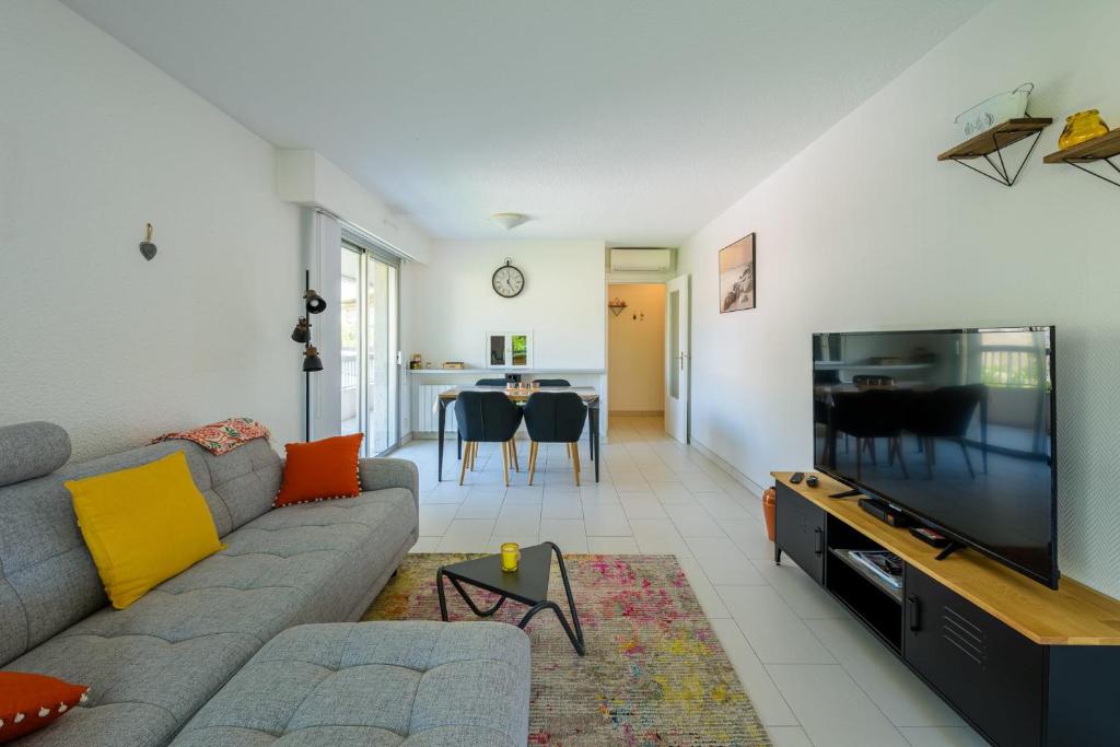 un salon avec un canapé et une télévision à écran plat dans l'établissement Lovely cosy nest close to the centre of Cannes, à Cannes