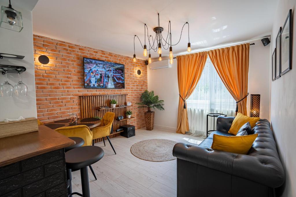 ein Wohnzimmer mit Sofa und Ziegelwand in der Unterkunft Holiday in Alba Iulia