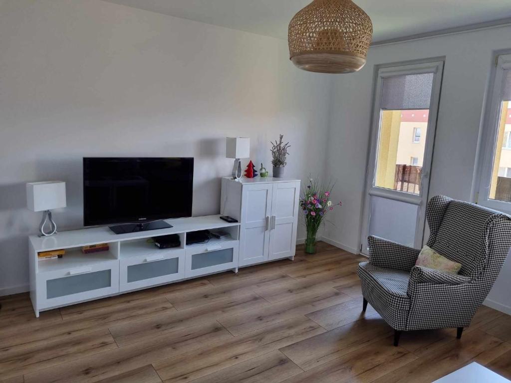 uma sala de estar com um centro de entretenimento branco com uma televisão de ecrã plano em Apartament Północna przy Suntago, Deepspot em Mszczonów