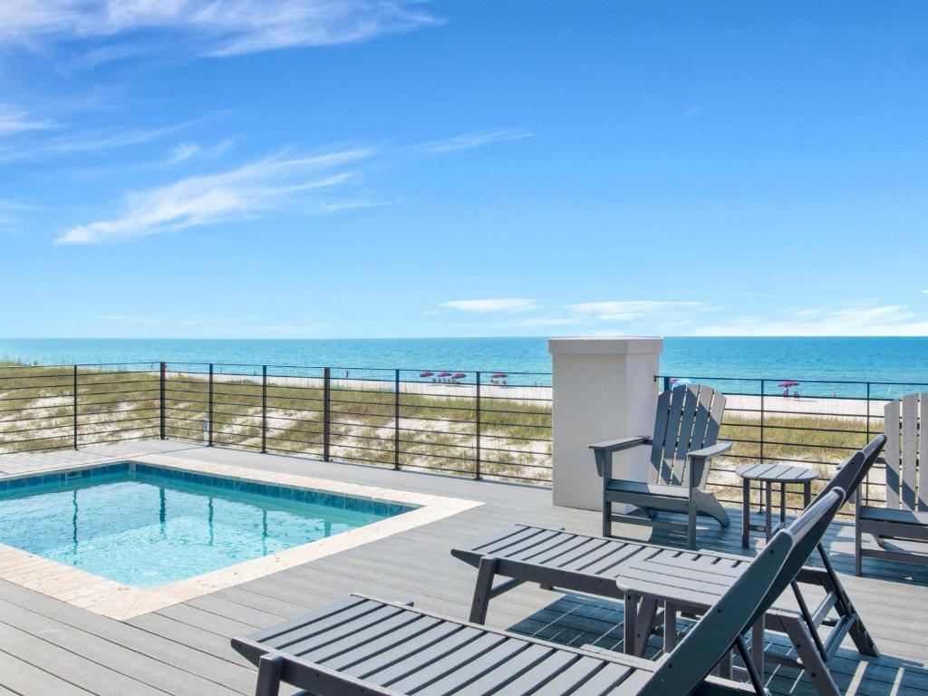 une terrasse avec une piscine, des chaises et l'océan dans l'établissement Viviana 5, à Pensacola
