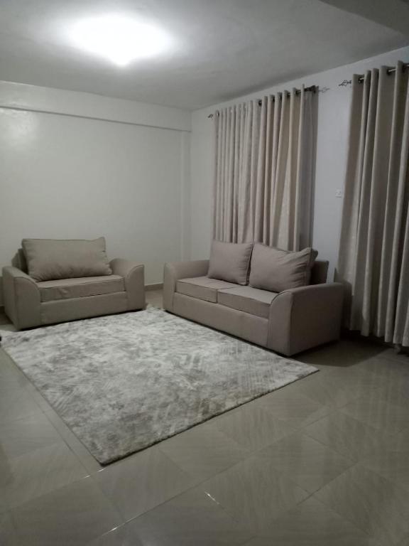 una sala de estar con 2 sofás y una alfombra en Cloud9 bnb kericho Annex, en Kericho